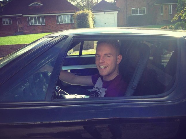 Josh Clayton sitting inside a black car and smiling