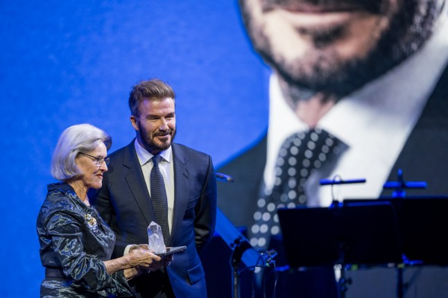 Former England's football player and UNICEF Goodwill Ambassador David Beckham (R) receives his prize from Schwab Foundation for Social Entrepreneurship chairperson Hilde Schwab during the Crystal Award ceremony at the World Economic Forum (WEF) annual meeting in Davos on January 20, 2025. (Photo by Fabrice COFFRINI / AFP) (Photo by FABRICE COFFRINI/AFP via Getty Images)