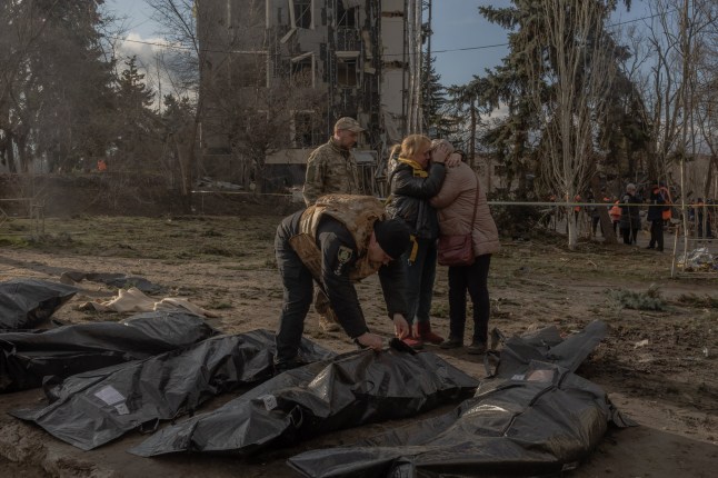 EDITORS NOTE: Graphic content / (FILES) Women react as a Ukrainian police officer shows them in a plastic bag the body of a killed person at the site of a missile attack in Izyum, Kharkiv region, on February 4, 2025, amid the Russian invasion of Ukraine. A Russian missile attack on February 4, 2025 on the Ukrainian city of Izyum, briefly occupied by Russia in 2022, killed five people and wounded three dozen more, officials said. (Photo by Roman PILIPEY / AFP) (Photo by ROMAN PILIPEY/AFP via Getty Images)