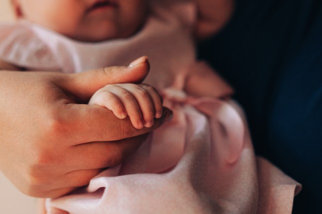Baby's Hand in Mother's Embrace