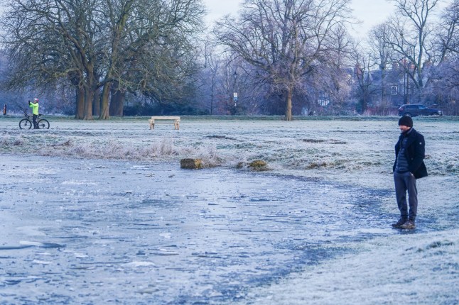 Mandatory Credit: Photo by Amer Ghazzal/Shutterstock (15096824q) A walker stands by the frozen pond on on Wimbledon Common this morning . The met office has issued an amber cold weather health alert for England as the cold spell is set to last until Tuesday with low temperatures dropping to -18Celsius in parts of the country Freezing temperatures on Wimbledon Common, Wimbledon Common, London, United Kingdom - 12 Jan 2025