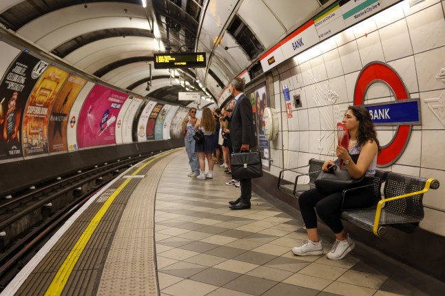 A commuter waiting for a train at Bank station on the London Underground platform.