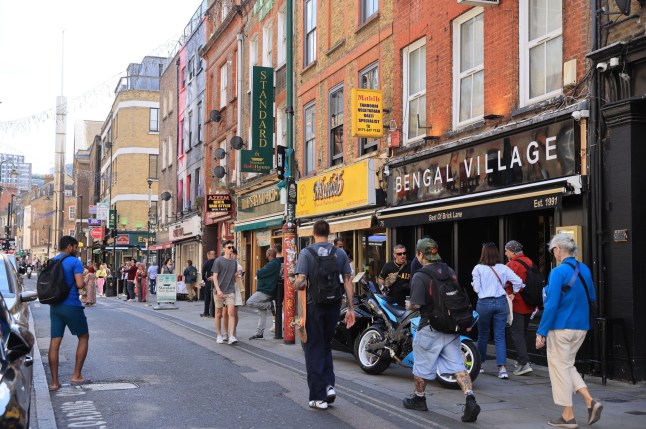 2X8DB1E The colourful and vibrant area of Banglatown or Brick Lane, on Sunday market day, in early summer sunshine, east London, UK