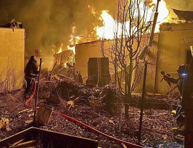 In this photo provided by the Ukrainian Emergency Service, firefighters put out the fire at the private houses following a Russian guided air bombs attack in Kherson, Ukraine, Saturday, March 15, 2025. (Ukrainian Emergency Service via AP)