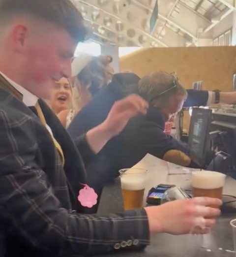 Man holding pint.