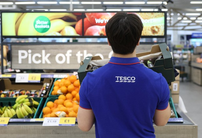 A Tesco worker replenishes fresh produce stock at a Tesco Extra supermarket in Cheshunt, Britain, March 25, 2025. REUTERS/Toby Melville