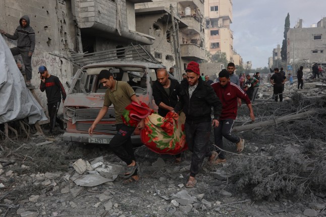 TOPSHOT - EDITORS NOTE: Graphic content / Palestinians carry the body of a victim after it was dug out from the rubble of a destroyed school, a day after it was hit by an Israeli strike, in the al-Tuffah neighbourhood of Gaza City on April 4, 2025. Gaza's civil defence agency said on April 3 that at least 31 people, including children, were killed in the Israeli strike on the school serving as a shelter for Palestinians displaced by the war. (Photo by Omar AL-QATTAA / AFP) (Photo by OMAR AL-QATTAA/AFP via Getty Images)