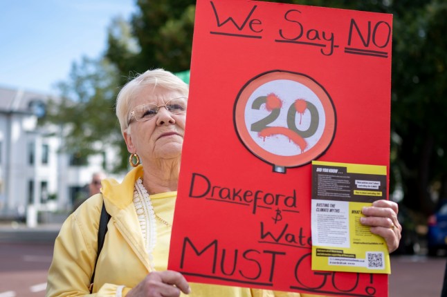 CARDIFF, WALES - SEPTEMBER 23: A woman holds a sign during a protest against 20mph speed limits on September 23, 2023 in Cardiff, Wales. A default 20mph speed limit has been introduced on restricted roads across Wales. As of September 23, 402,000 people had signed a protest opposing the move. (Photo by Matthew Horwood/Getty Images)