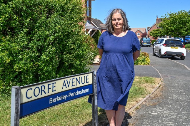Councillor Sarah Murray standing at a road sign for Corfe Avenue in Worcester