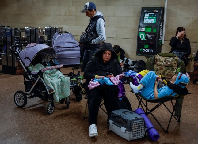 People take shelter inside a metro station with their children and pet during a Russian military strike, amid Russia's attack on Ukraine, in Kyiv, Ukraine May 25, 2025. REUTERS/Alina Smutko