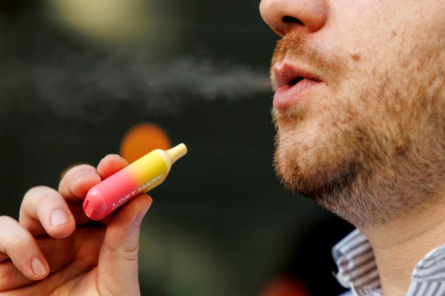 A man smoking a Lost Mary disposable vape.