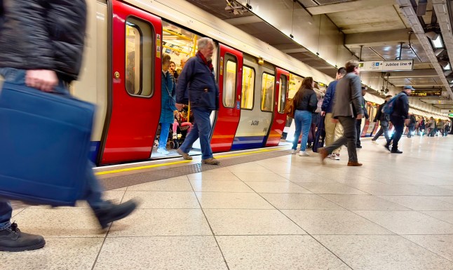 Passengers stepping out of a London Underground train.
