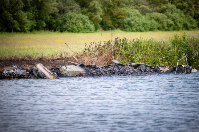Remains of a fire on the River Thames banks after a boat exploded.