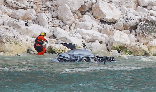 Dramatic pictures show the wreckage of a car which plunged hundreds of feet off a tall cliff. Photos show the twisted metal of the silver vehicle which ended up in the water below. Police, firefighters, paramedics and coastguards all attended the scene following reports of a 'serious incident'. It is understood that a man has been 'recovered' from the water by a lifeboat volunteer. Emergency services were called at around 7.20pm Friday evening to Alum Bay in the Isle of Wight, Hants. SEE OUR COPY FOR DETAILS. Please byline: Paul Blackley/Solent News ?? Paul Blackley/Solent News & Photo Agency UK +44 (0) 2380 458800