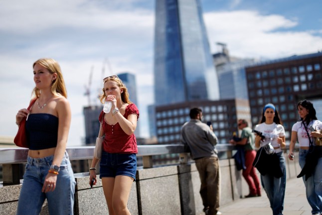 epa12201294 Peopler cross London Bridge and hydrate during a warm day in London, Britain, 27 June 2025. A second summer heatwave arrives in Britain with an amber weather alert issued across most of England due to temperatures expected to rise up to 34-35 degrees Celsius in the coming days. EPA/TOLGA AKMEN