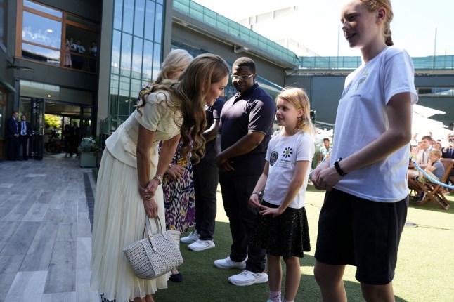 Britain's Catherine, Princess of Wales meets Lydia Lowe, eight, from the Dan Maskell Tennis Trust, as she arrives to attend the Ladies' Singles Final of the 2025 Wimbledon Championships at the All England Lawn Tennis and Croquet Club, London, Britain. Picture date: Saturday July 12, 2025. Jordan Pettitt/Pool via REUTERS