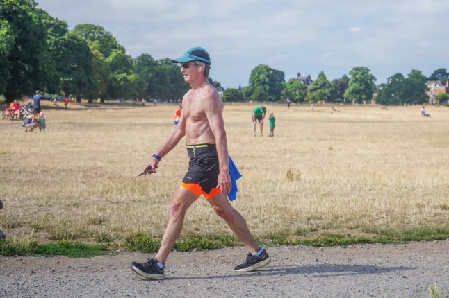 Mandatory Credit: Photo by Amer Ghazzal/Shutterstock (15397265f) A man walking in the bright sunshine on a parched Wimbledon Common. An amber heat health alert has been issued for southern England - where it is hottest until the end of the heatwave as the heat has also affected sporting events, with Wimbledon fans braving close to the hottest women's finals day at the tennis championship.s Seasonal Weather, Wimbledon, London, United Kingdom - 13 Jul 2025