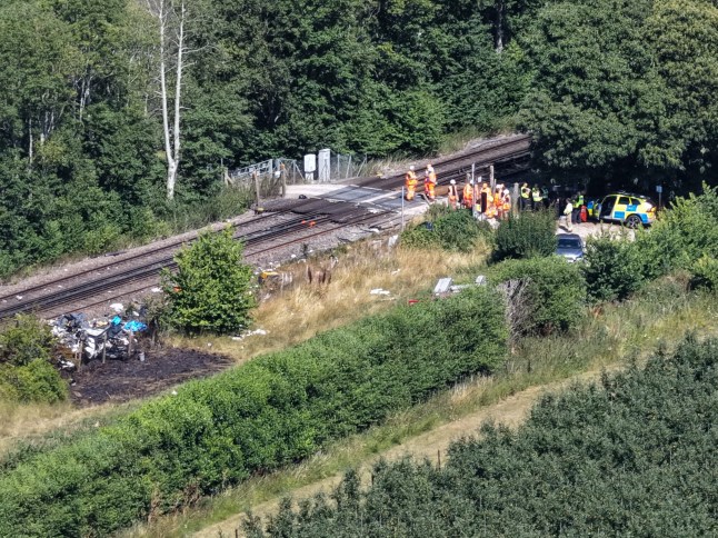A London-bound train has collided with a van on a level crossing near Lower Road in Teynham, resulting in the death of the van driver, who is understood to have been an Amazon delivery driver. The collision occurred at high speed just after 12:45pm and caused the van to catch fire. Emergency services, including Kent Police, British Transport Police, and the air ambulance, attended the scene. The railway line between Newington and Faversham remains blocked in both directions, and a major investigation is underway. Official Police Statement In a statement issued this afternoon, British Transport Police said: ???Officers were called to the line in Tonge just after 12.45pm today (13 July) following reports of a train striking a van. Paramedics also attended, however sadly a person was pronounced dead at the scene. The incident is currently being investigated.??? 200 Passengers Evacuated Around 200 train passengers were trapped on board for several hours following the collision. They were eventually detrained and transferred to another train under the supervision of emergency crews. Road Closures and Disruption Several local road closures remain in effect while recovery and investigation work continues. Train services between Newington and Faversham are cancelled or delayed, and disruption is expected until at least 3:00pm. Southeastern and National Rail have advised passengers to check for live updates and seek alternative travel routes.
