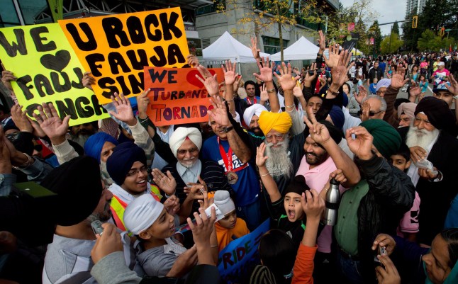 Mandatory Credit: Photo by Canadian Press/Shutterstock (1895082g) Fauja Singh is surrounded by supporters after finishing the race 101-year-old marathon runner Fauja Singh running in a 5km race in Surrey, British Columbia, Canada - 30 Sep 2012 101-year-old British marathon runner Fauja Singh is seen running in a 5km race in British Columbia, Canada. Singh is believed to be the oldest marathon runner in the world. He was born in India in 1911 but currently lives in London. He only started running in his eighties, and has jogged 10 miles a day since. To date he has run eight marathons and holds the record for the men's over-90 category after running the Toronto marathon in five hours and 40 minutes in 2003. He also holds UK records for the 200 metres, 400m, 800m, one mile and 3000m for his age group. Fauja recently acted as an London 2012 Olympics torch bearer and has also appeared in an Adidas campaign alongside David Beckham and Muhammad Ali. He credits his long life and amazing fitness to ginger curry and drinking lot of tea.