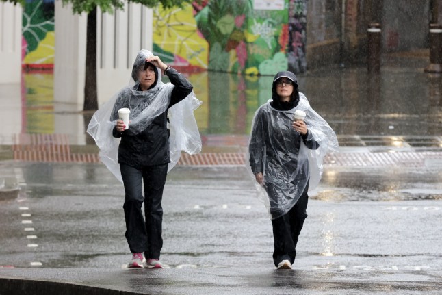 LONDON, UNITED KINGDOM - JULY 19: Women wearing rain ponchos during rainfall while walking in Westminster, London, United Kingdom, on July 19, 2025. The Met Office has issued an amber weather warning, forecasting continued heavy downpours and thunderstorms throughout the day across parts of south-east and eastern England, including London, following a recent heatwave. (Photo by Stringer/Anadolu via Getty Images)
