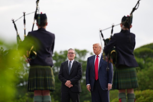 BALMEDIE, SCOTLAND - JULY 28: U.S. President Donald Trump and British Prime Minister Keir Starmer stand in front of some people playing the bagpipes at Trump International Golf Links on July 28, 2025 in Balmedie, Aberdeenshire, Scotland. The pair met at Trump Turnberry this morning before traveling together to Aberdeenshire to have a private dinner at another Trump-owned golf club. President Trump is visiting Scotland in a trip that???s part-vacation, part-work, as he stayed at his Trump Turnberry golf course, followed by the Trump International Golf Links in Aberdeenshire, between July 25 to 29. (Photo by Andrew Harnik/Getty Images)