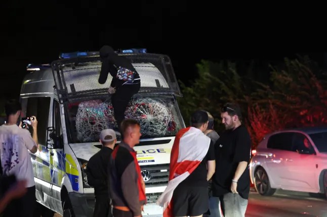 Someone smashes up the windscreen of a police van (UKNIP)
