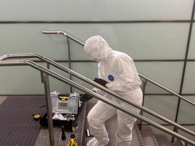 Forensics take fingerprint search of the staircase rail