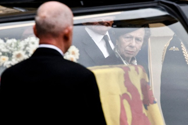 TOPSHOT - Britain's Princess Anne, Princess Royal, (R) looks toward the coffin of the late Queen Elizabeth II, draped with the Royal Standard of Scotland, after arriving at the Palace of Holyroodhouse, in Edinburgh on September 11, 2022. - Queen Elizabeth II's coffin will travel by road through Scottish towns and villages on Sunday as it begins its final journey from her beloved Scottish retreat of Balmoral. The Queen, who died on September 8, will be taken to the Palace of Holyroodhouse before lying at rest in St Giles' Cathedral, before travelling onwards to London for her funeral.. (Photo by ALKIS KONSTANTINIDIS / POOL / AFP) (Photo by ALKIS KONSTANTINIDIS/POOL/AFP via Getty Images)