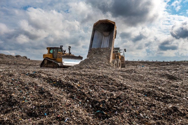 Dumper truck unloading waste on landfill site