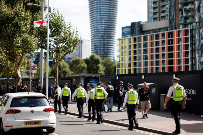 epa12340176 Police officers walk along a street during a 'Stand Up to Racism' demonstration against the far-right, outside the Britannia Hotel in Canary Wharf, London, Britain, 31 August 2025. Protests by far-right groups outside hotels housing migrants have been increasing across the UK in recent weeks, with counter-protests also taking place. EPA/TOLGA AKMEN