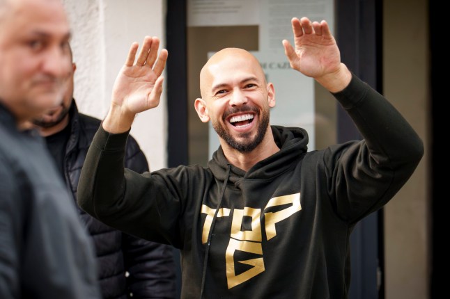 Andrew Tate laughs before checking in at a police station as part of his judicial control, which requires him to appear before judicial authorities in Romania when summoned, in Voluntari, Romania, Monday, March 24, 2025. (AP Photo/Vadim Ghirda)