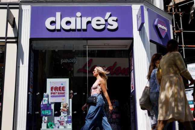 A woman walking past a Claire's Accessories shop on the high street