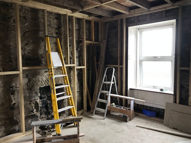 The cottage during renovation. // A couple who bought their grandparent's old cottage were stunned when they renovated it - and found notes from them behind the wallpaper. The grey cottage in the Aberdeenshire village of New Deer used to belong to Mark Strathan's late grandparents, Nellie and Wullie. When Mark Strathan and Mark Cunningham stripped the old wallpaper they uncovered notes on the walls - including handwritten signatures by Mr Strathan's grandparents. Photo released 28/09/2025