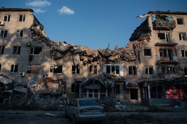 This photograph taken on September 27, 2025 shows a car parked next to a destroyed building in Avdiivka, a Russian-controled Donetsk region of Ukraine, amid the ongoing Russian-Ukrainian conflict. (Photo by Andrey BORODULIN / AFP) (Photo by ANDREY BORODULIN/AFP via Getty Images)