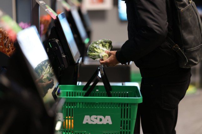 A shopper scans items at the Asda Express convenience store, operated by Asda in London.
