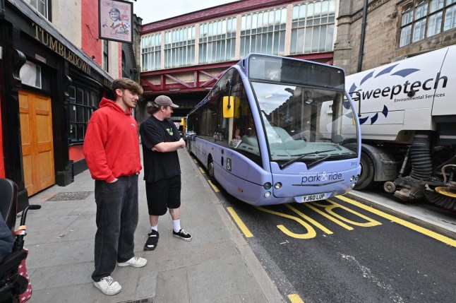 People look at a bus blocking traffic