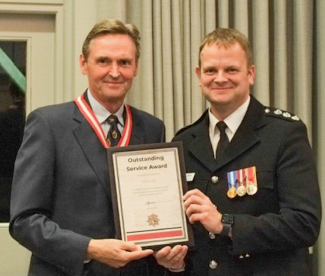 Pictured: John Linden (L) being awarded an Outstanding Service Award. A senior firefighter has won an unfair dismissal case after he threw a nuisance YouTuber's phone over a hedge following a row. John Linden, who has 32 years of experience, was sacked after the incident with disabled YouTuber Jimmy Evans, a tribunal heard. Mr Evans was filming the incident for his YouTube channel, but became 'aggressive and obstructive' when Mr Linden mentioned calling the police to move him back to a safe distance. The independent journalist pushed his phone into Mr Linden's face, and the firefighter 'grabbed' it off him and threw it over the nearby hedge. SEE OUR COPY FOR DETAILS. Please byline: Solent News ?? Solent News & Photo Agency UK +44 (0) 2380 458800