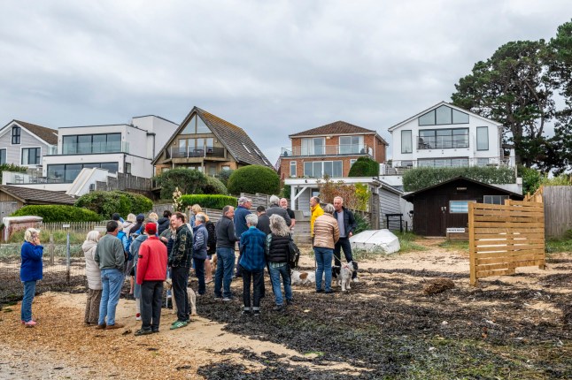 BNPS.co.uk (01202 558833) Pic: BNPS Pictured: Sandbanks residents gathered on the beach. Get orf my beach.. Sandbanks residents have instructed lawyers to take legal action after a 'public' beach behind a row of multi-million mansions was fenced off in an apparent 'land-grab'. For decades people have enjoyed unrestricted access to the sandy foreshore on the northern side of the exclusive peninsula in Poole Harbour, Dorset. It is a favourite spot for dog walkers, sea swimmers and paddlers and for those taking in a sunset stroll.