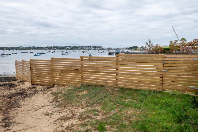BNPS.co.uk (01202 558833) Pic: BNPS Pictured: The fence. Get orf my beach.. Sandbanks residents have instructed lawyers to take legal action after a 'public' beach behind a row of multi-million mansions was fenced off in an apparent 'land-grab'. For decades people have enjoyed unrestricted access to the sandy foreshore on the northern side of the exclusive peninsula in Poole Harbour, Dorset. It is a favourite spot for dog walkers, sea swimmers and paddlers and for those taking in a sunset stroll.