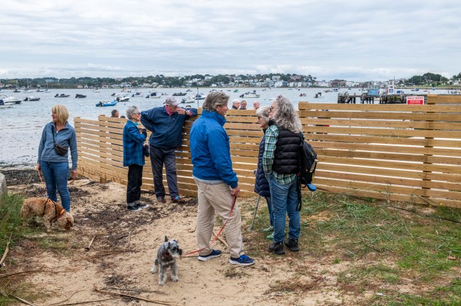 BNPS.co.uk (01202 558833) Pic: BNPS Pictured: Sandbanks residents gathered on the beach. Get orf my beach.. Sandbanks residents have instructed lawyers to take legal action after a 'public' beach behind a row of multi-million mansions was fenced off in an apparent 'land-grab'. For decades people have enjoyed unrestricted access to the sandy foreshore on the northern side of the exclusive peninsula in Poole Harbour, Dorset. It is a favourite spot for dog walkers, sea swimmers and paddlers and for those taking in a sunset stroll.