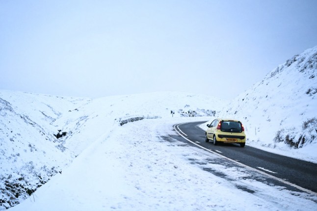 TOPSHOT - A person drives a car past a landscape covered in snow and along the Snake pass road, in the Peak district, northern England, on January 8, 2025 after heavy snow and rain across large parts of England caused disruption over the weekend. (Photo by Oli SCARFF / AFP) (Photo by OLI SCARFF/AFP via Getty Images)