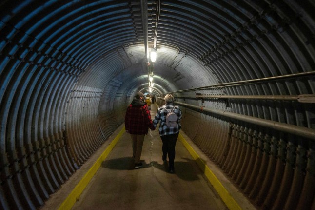 People arrive enter the Diefenbunker, Canada's Cold War Museum, in Ottawa on October 5, 2022. - The Diefenbunker, formerly known as Canadian Forces Station Carp (CFS Carp), is a four story underground concrete fallout shelter/bunker that was operational between 1959 and 1994. During operations 555 people could survive in the bunker for a month without outside supplies. The Diefenbunker is named after Canada's former Prime Minister John Diefenbaker, who authorized the project. (Photo by Lars Hagberg / AFP) (Photo by LARS HAGBERG/AFP via Getty Images)