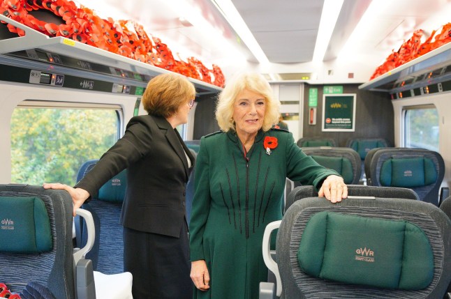 Queen Camilla travels on a poppy filled train carriage to Paddington.