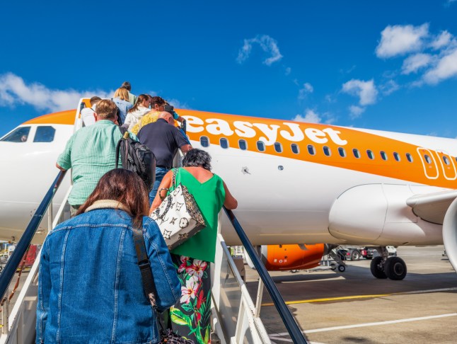 A view of people climbing the stairs to board an Easyjet flight