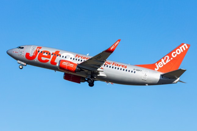 A Jet2 Boeing 737-700 plane flying amid the blue sky.