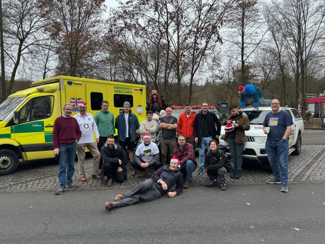 A host of volunteers for Driving Ukraine pose in front of the vehicles they're donating to Ukraine.