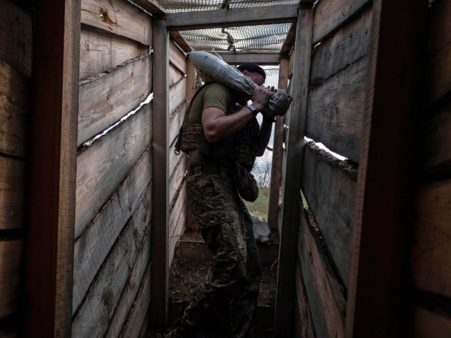 In this photo provided by Ukraine's 93rd Kholodnyi Yar Separate Mechanized Brigade press service, a soldier carries a shell to fire towards positions of Russian troops near Kostyantynivka in Donetsk region, Ukraine, Tuesday, Aug. 26, 2025. (Iryna Rybakova/Ukraine's 93rd Mechanized Brigade via AP)