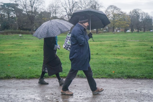 Mandatory Credit: Photo by Amer Ghazzal/Shutterstock (15875260c) Pedestrians with umbrellas crossing Wimbledon Common, south west London on a wet and blusterty. The forecast is for rain this weekend as temperatures are expected to reach lows of -5C in rural southern England. Seasonal Weather, Wimbledon Common, London, United Kingdom - 22 Nov 2025