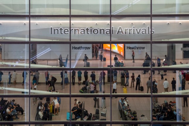 The Queens Building at Heathrow Terminal 2 building with passengers arriving and people waiting to meet them.