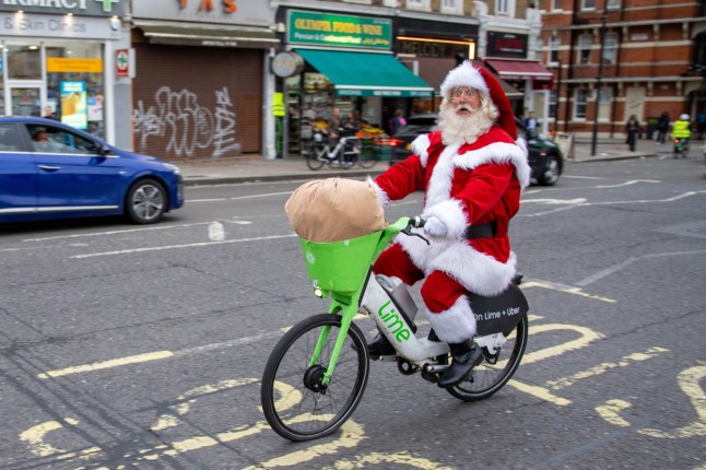 A man dressed as Santa riding a Lime rental e-bike in London.